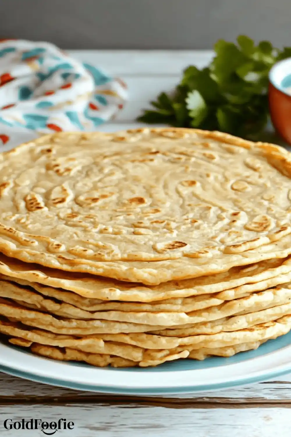 1-Ingredient Red Lentil Tortillas That Work 5 Foldable red lentil tortillas stacked on a plate with a tea towel in the background