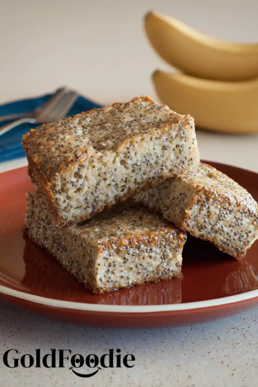 Banana Chia Seed Cake with Whole Bananas Banana chia cake slices on a red plate with bananas