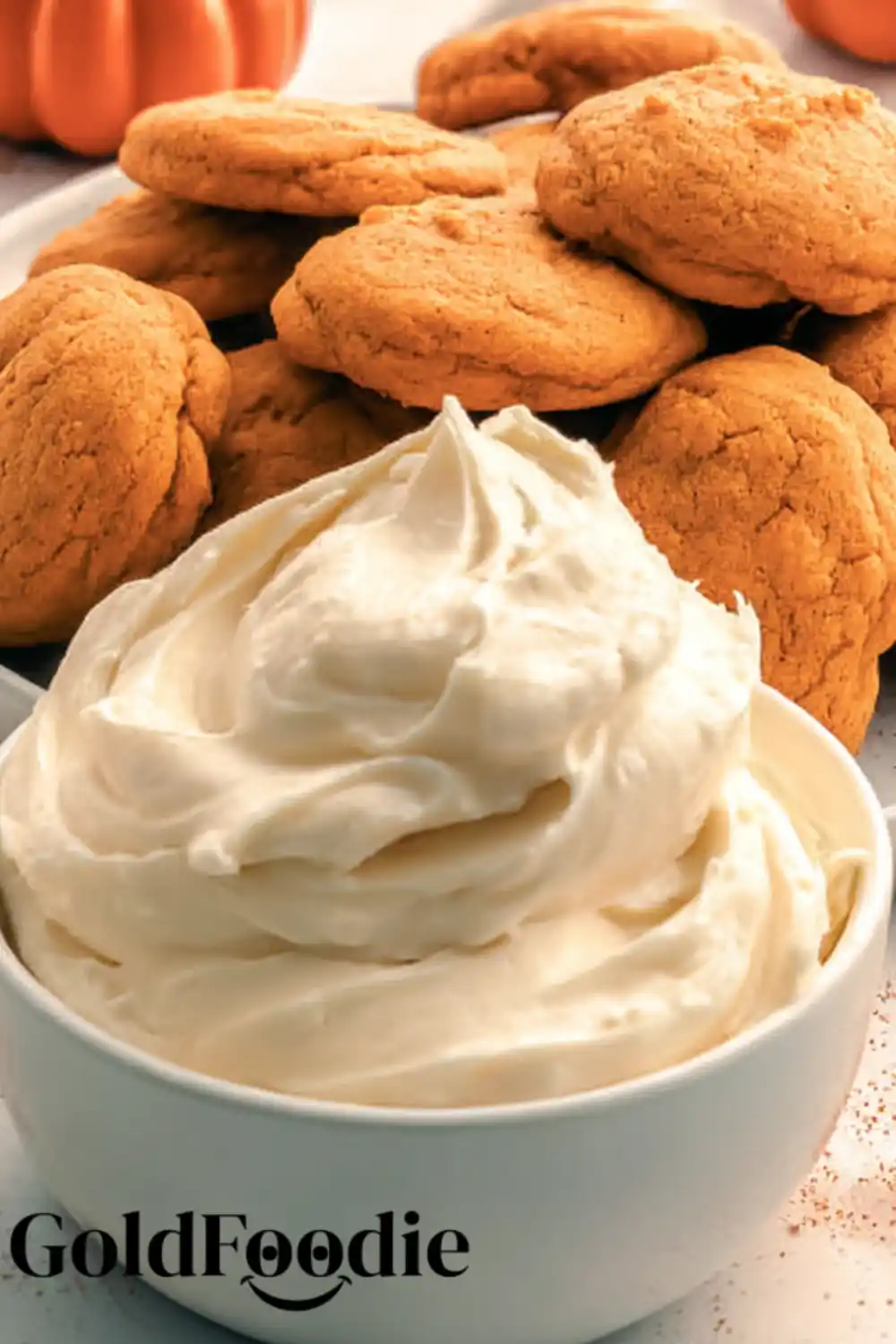Frosting Bowl and Pumpkin Cookies Spreading cream cheese frosting on pumpkin cookie