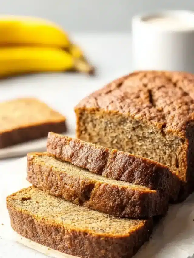Coconut Banana Bread loaf sliced on parchment with a soft crumb texture.