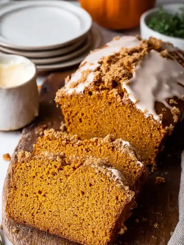 Three slices of pumpkin bread on a board.