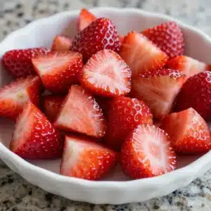 Close-up of a bowl filled with vibrant strawberry rhubarb pie filling.