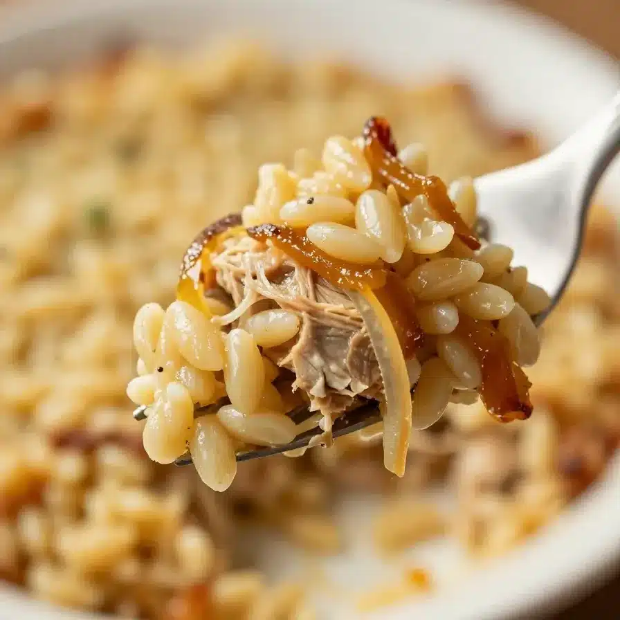 French Onion Chicken Orzo Casserole 5 A close-up of French Onion Chicken Orzo Casserole served in a white baking dish.
