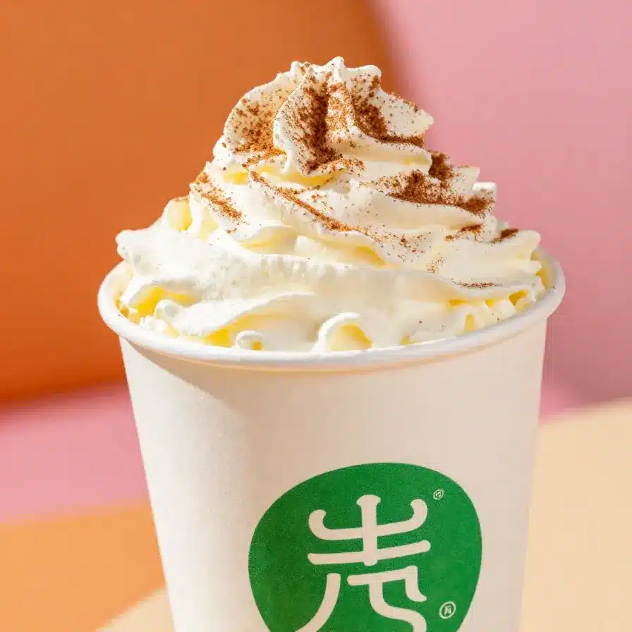A steaming cup of skinny pumpkin spice latte topped with foam and cinnamon.