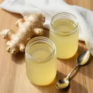 A bowl of gut healing ginger honey jello topped with fresh ginger slices