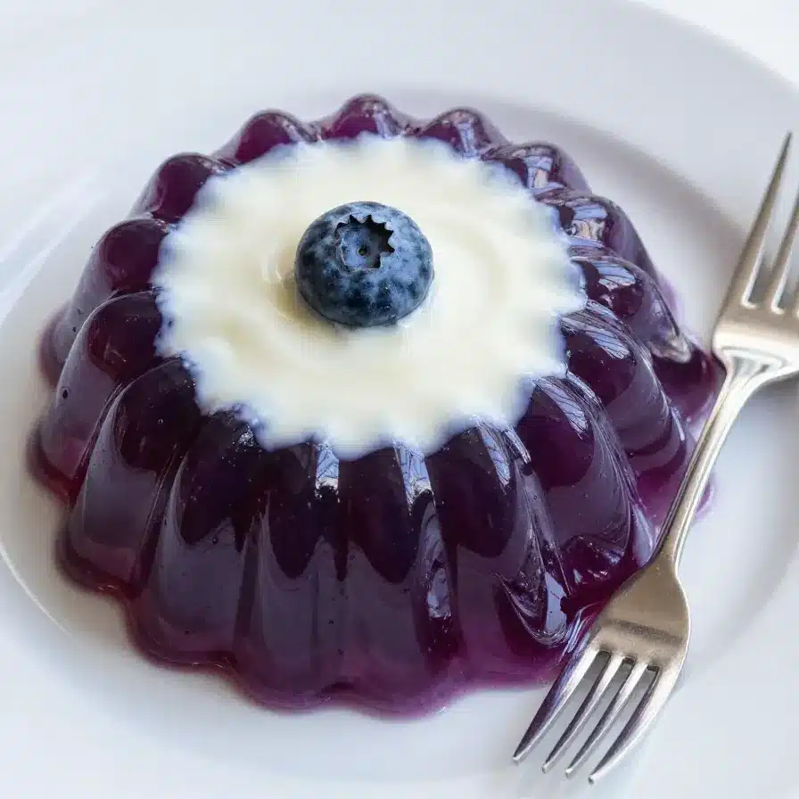 Blueberry Jello Salad 5 A colorful bowl of blueberry jello salad topped with fresh blueberries and whipped cream