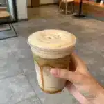 Starbucks White Mocha and Caramel Drink 1 A Starbucks cup filled with white mocha and caramel drink topped with whipped cream.