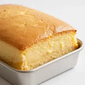 A slice of easy pumpkin pie poke cake topped with whipped cream and a sprinkle of cinnamon