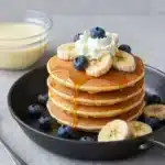 Fluffy Banana Pancakes for a Delightful Morning Treat 2 A stack of fluffy banana pancakes topped with sliced bananas and syrup