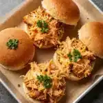 Buffalo Chicken Sliders 4 Close-up of buffalo chicken sliders on a wooden serving board.