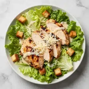 A fresh Chicken Caesar Salad with grilled chicken, romaine lettuce, croutons, and Parmesan cheese
