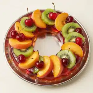 A colorful dessert of cream cheese gelatin topped with assorted fruits