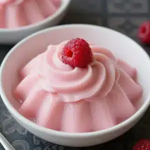 A bowl of vibrant sugar-free keto jello whips topped with whipped cream and berries