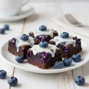 Fresh blueberry brownies with a rich chocolate base and scattered blueberries on top, cut into neat squares.