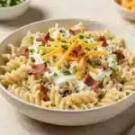 Bacon Ranch Pasta Salad 3 A bowl of bacon ranch pasta salad with rotini pasta, crispy bacon, cherry tomatoes, and chopped parsley