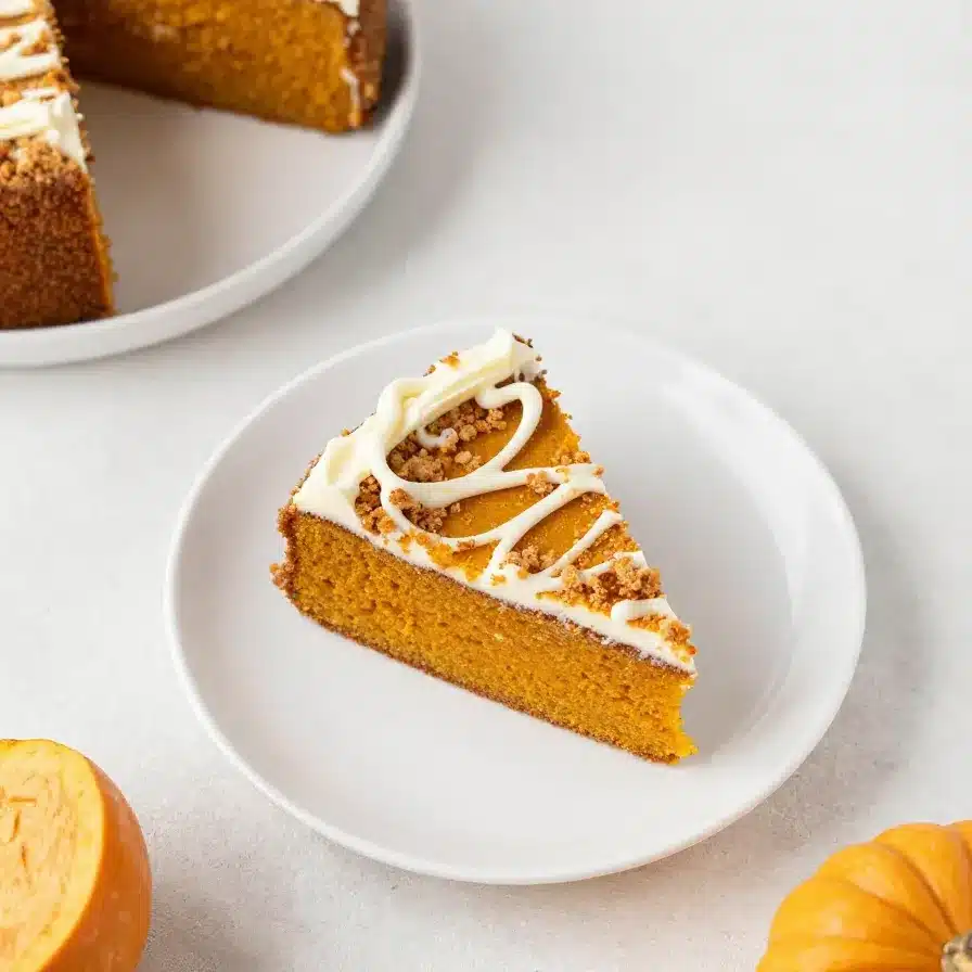 Pumpkin Cake 5 A slice of pumpkin cake with creamy frosting on a white plate